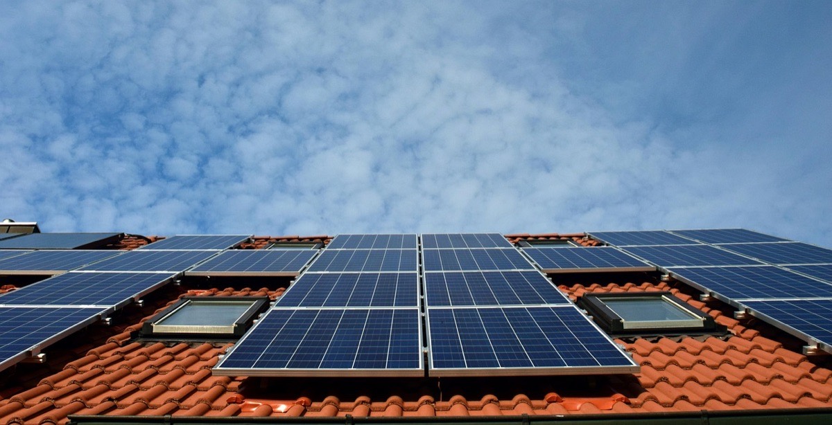 Solar panels on mounting feet standing clear of a barrel tile roof, with a gap between the panels and the tiles